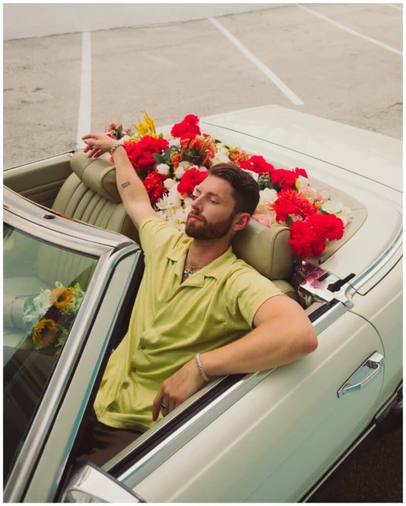 A person sitting in a car with a bouquet of flowers on the head

Description automatically generated with medium confidence